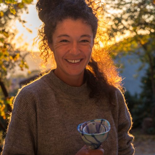 Anna hold a ceramic flower at her ceramics laboratory