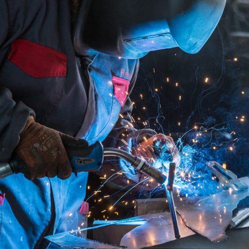 Giorgia arc welds a sculpture in her workshop