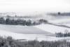 Snow and mist cover the hills of Moncalvo, Basso Monferrato, Piedmont, Italy